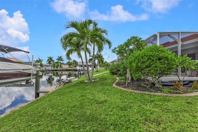 view of yard with a boat dock, a lanai, and a water view