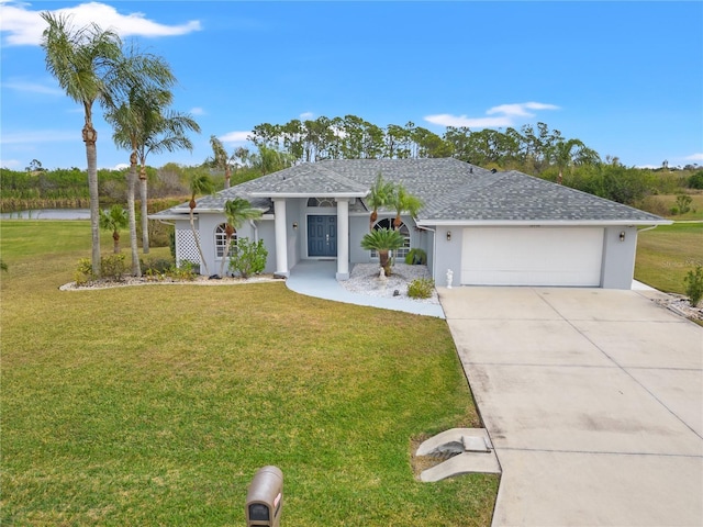 view of front facade featuring a garage, a water view, and a front lawn