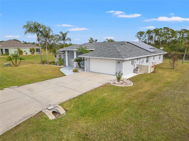 single story home featuring solar panels, a front yard, central AC unit, and a garage