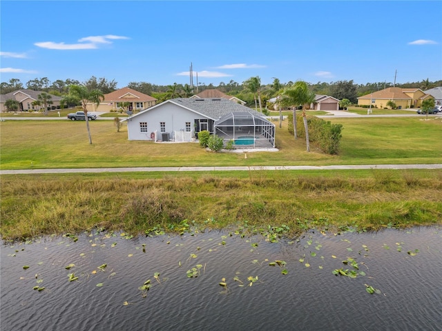 back of house with a water view, a lanai, and a yard