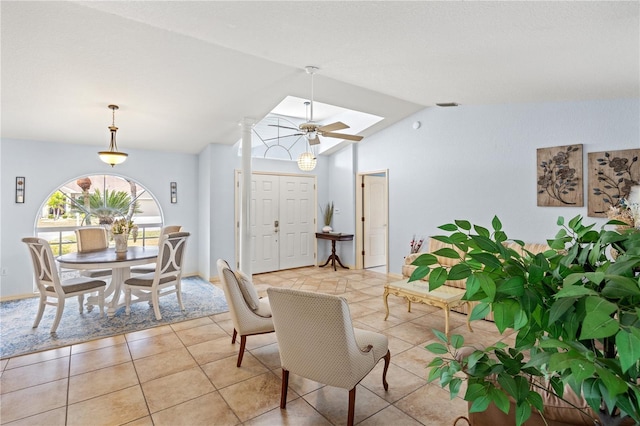 dining space with ceiling fan, light tile patterned floors, and vaulted ceiling