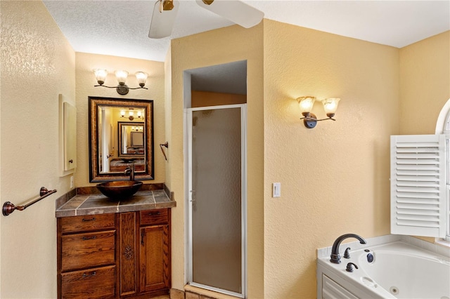 bathroom with independent shower and bath, a textured ceiling, ceiling fan, and vanity