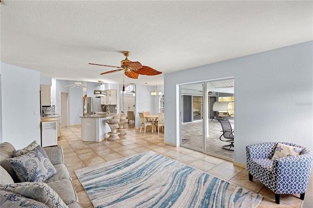 tiled living room featuring a textured ceiling and ceiling fan