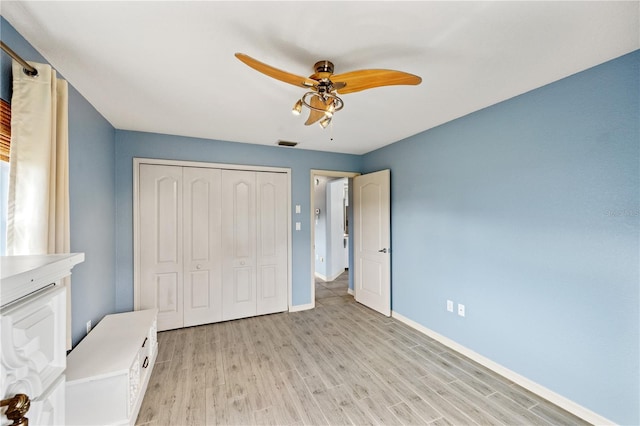 unfurnished bedroom with light wood-type flooring, a closet, and ceiling fan