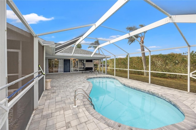 view of pool with glass enclosure and a patio