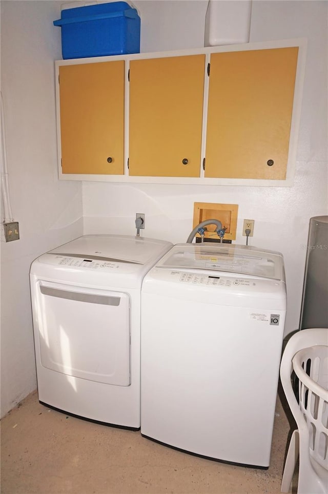 clothes washing area featuring cabinets and washing machine and dryer