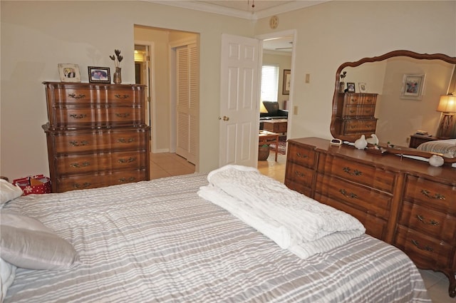 bedroom with a closet, ornamental molding, and light tile patterned flooring