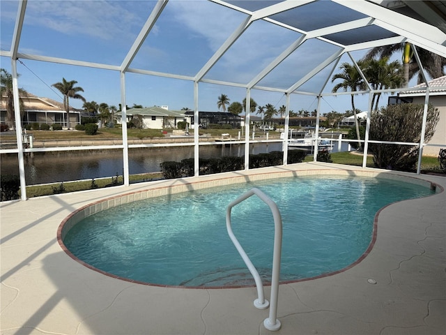 view of pool with glass enclosure and a water view