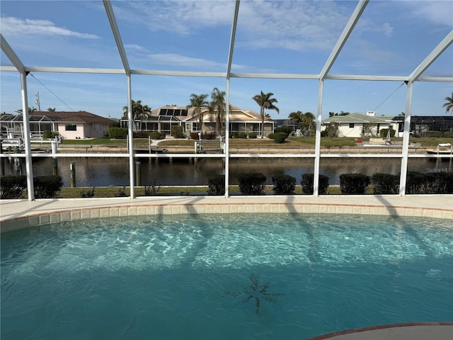 view of swimming pool with glass enclosure and a water view