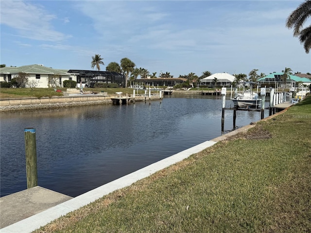 view of dock with a lawn and a water view