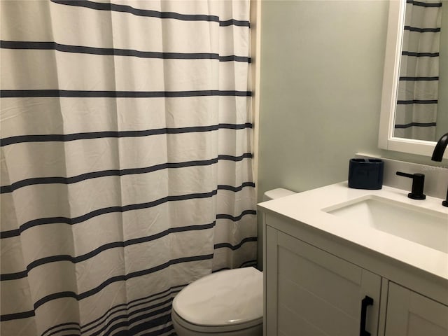 bathroom featuring vanity, toilet, and walk in shower