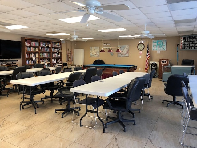 office area with ceiling fan and a drop ceiling