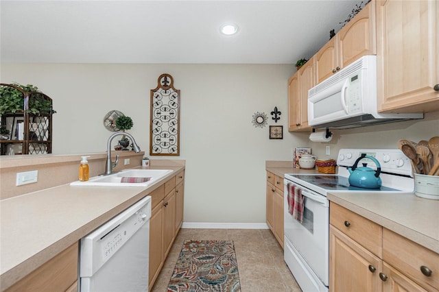 kitchen featuring light brown cabinetry, sink, white appliances, and light tile patterned floors