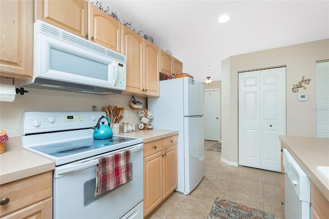 kitchen featuring white appliances, light tile patterned floors, and light brown cabinets