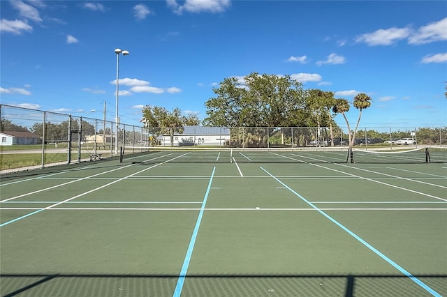 view of tennis court featuring basketball hoop