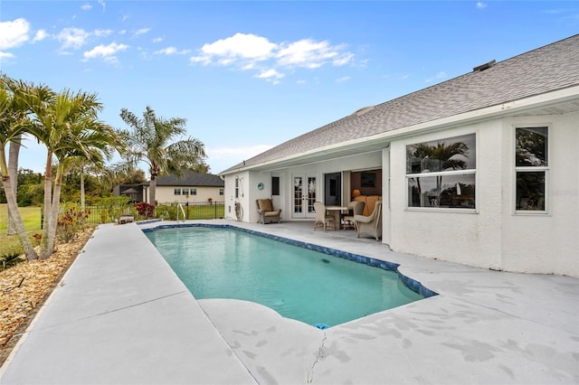 view of swimming pool featuring a patio and french doors