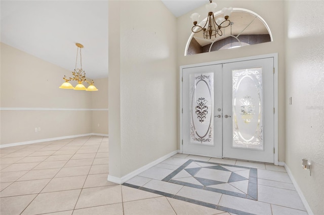 entrance foyer with light tile patterned floors, an inviting chandelier, and french doors