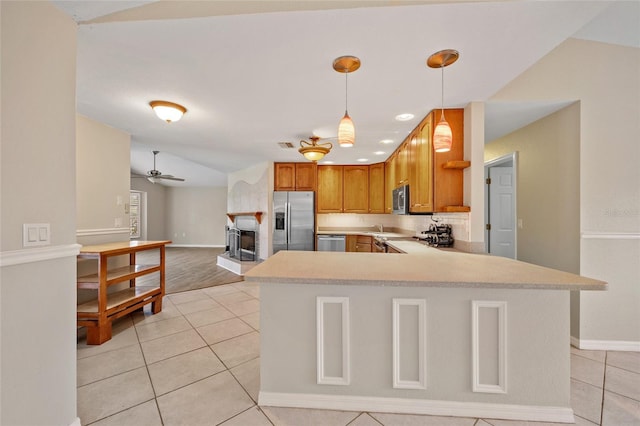 kitchen with pendant lighting, ceiling fan, appliances with stainless steel finishes, light tile patterned flooring, and kitchen peninsula