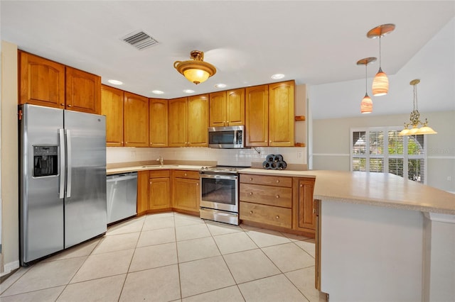 kitchen featuring appliances with stainless steel finishes, decorative light fixtures, sink, backsplash, and light tile patterned floors