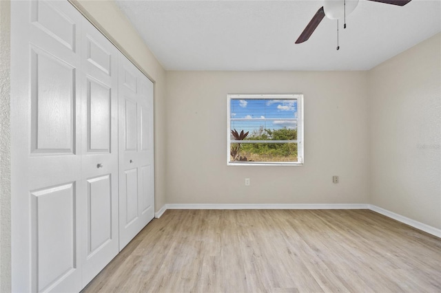 unfurnished bedroom featuring ceiling fan, light hardwood / wood-style floors, and a closet