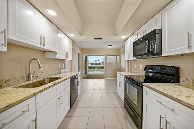 kitchen with black appliances, white cabinetry, light stone countertops, and sink