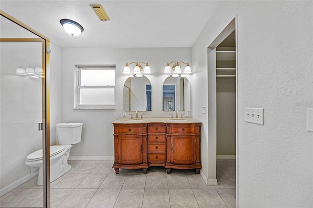 bathroom featuring toilet, vanity, and tile patterned flooring