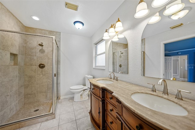 bathroom featuring a shower with shower door, tile patterned floors, toilet, and vanity