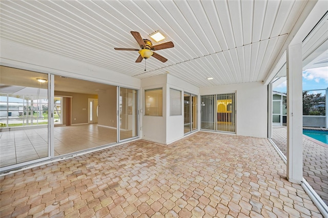 unfurnished sunroom featuring ceiling fan