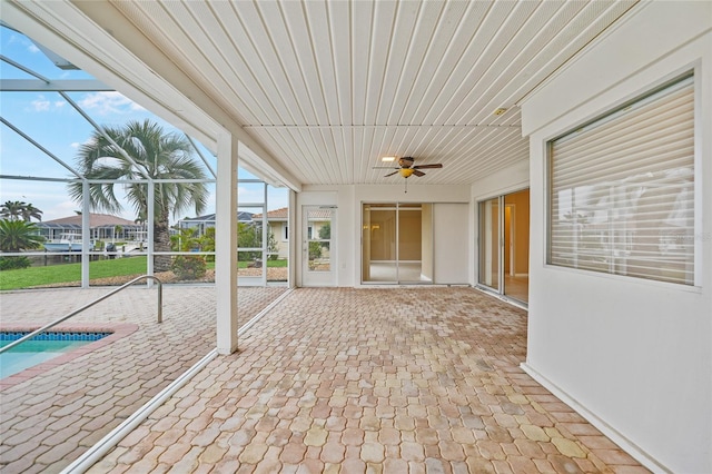 unfurnished sunroom with ceiling fan