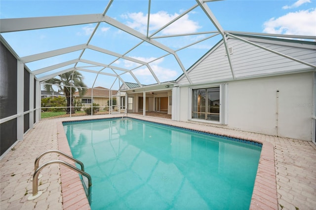 view of swimming pool featuring glass enclosure and a patio area