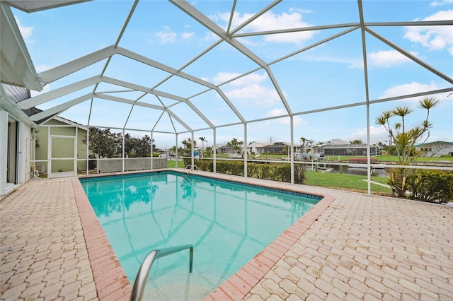 view of swimming pool with a lanai, a water view, and a patio