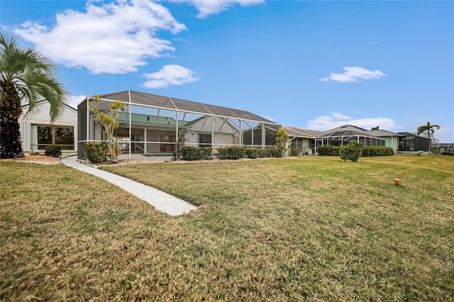 back of property with glass enclosure and a yard