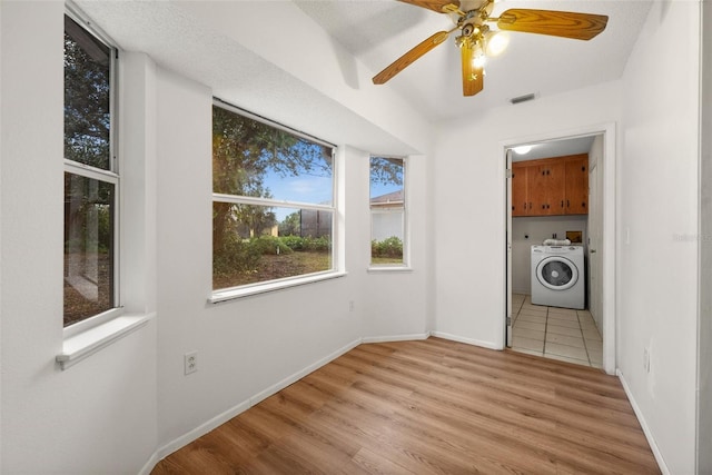 laundry area featuring light hardwood / wood-style flooring, washer / clothes dryer, and cabinets