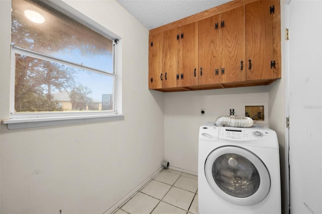 washroom featuring light tile patterned flooring, cabinets, a textured ceiling, and washer / clothes dryer