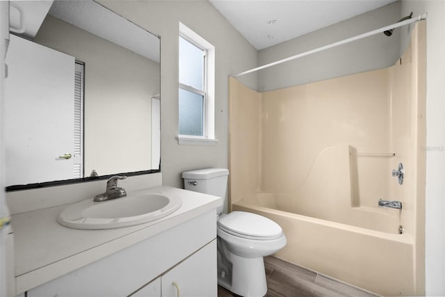 full bathroom with hardwood / wood-style flooring, tub / shower combination, toilet, and vanity