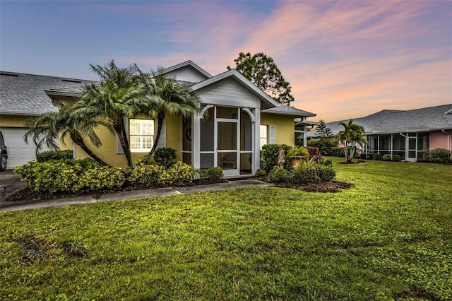 view of front of property with a lawn and a sunroom