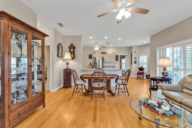 dining area with light hardwood / wood-style flooring and ceiling fan