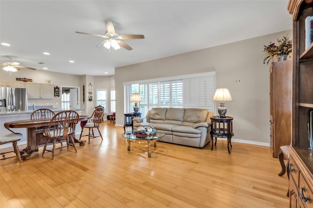 living room featuring ceiling fan and light hardwood / wood-style floors