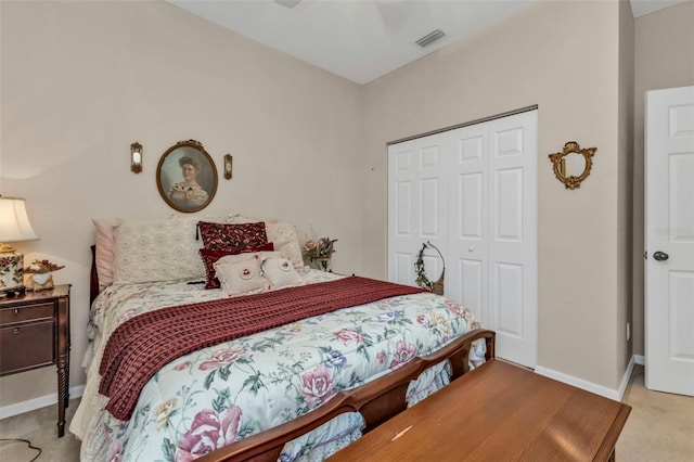 bedroom with light colored carpet, ceiling fan, and a closet