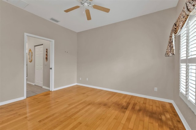 empty room with ceiling fan and light hardwood / wood-style flooring