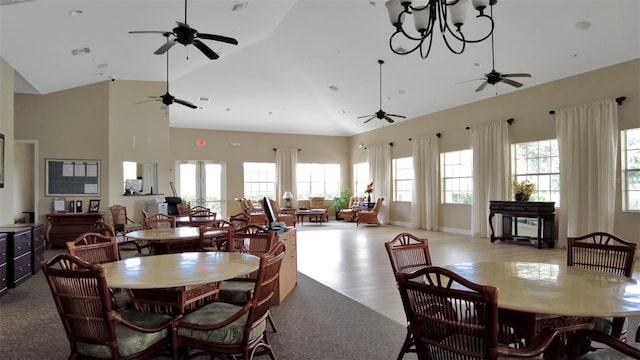 dining space with a chandelier, high vaulted ceiling, and light wood-type flooring