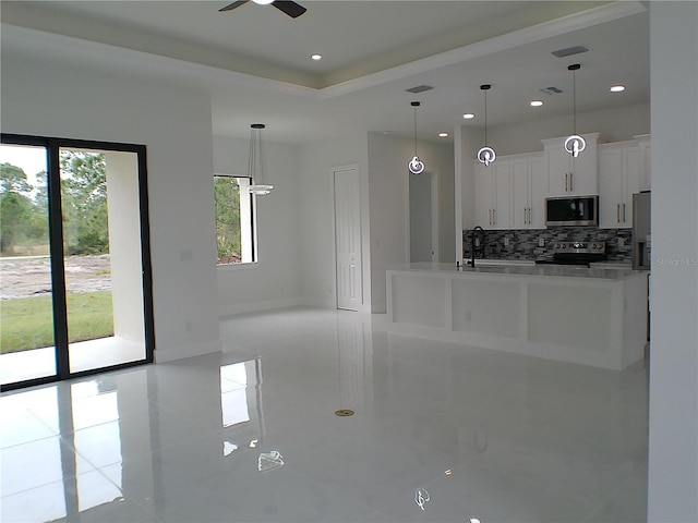 kitchen with decorative light fixtures, white cabinetry, backsplash, ceiling fan, and stainless steel appliances