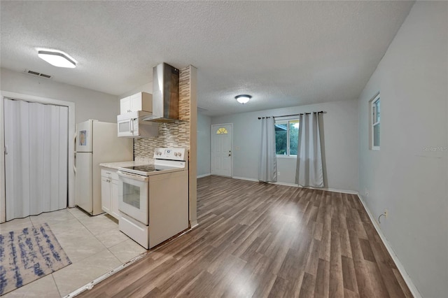 kitchen featuring white cabinetry, backsplash, white appliances, a textured ceiling, and wall chimney exhaust hood