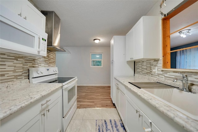 kitchen with white cabinets, sink, wall chimney range hood, and electric range