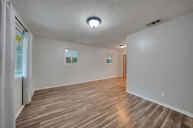 empty room featuring wood-type flooring and a textured ceiling