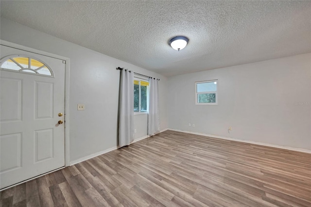 foyer entrance featuring light hardwood / wood-style flooring and a textured ceiling