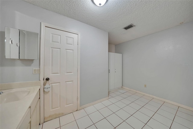 bathroom featuring vanity, tile patterned floors, and a textured ceiling