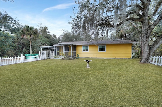 rear view of house with a sunroom and a lawn