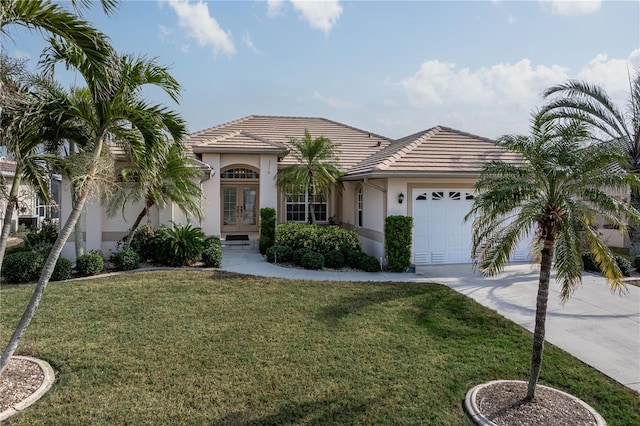 view of front of property featuring french doors, a garage, and a front lawn