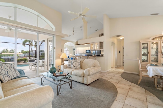 tiled living room with high vaulted ceiling and ceiling fan